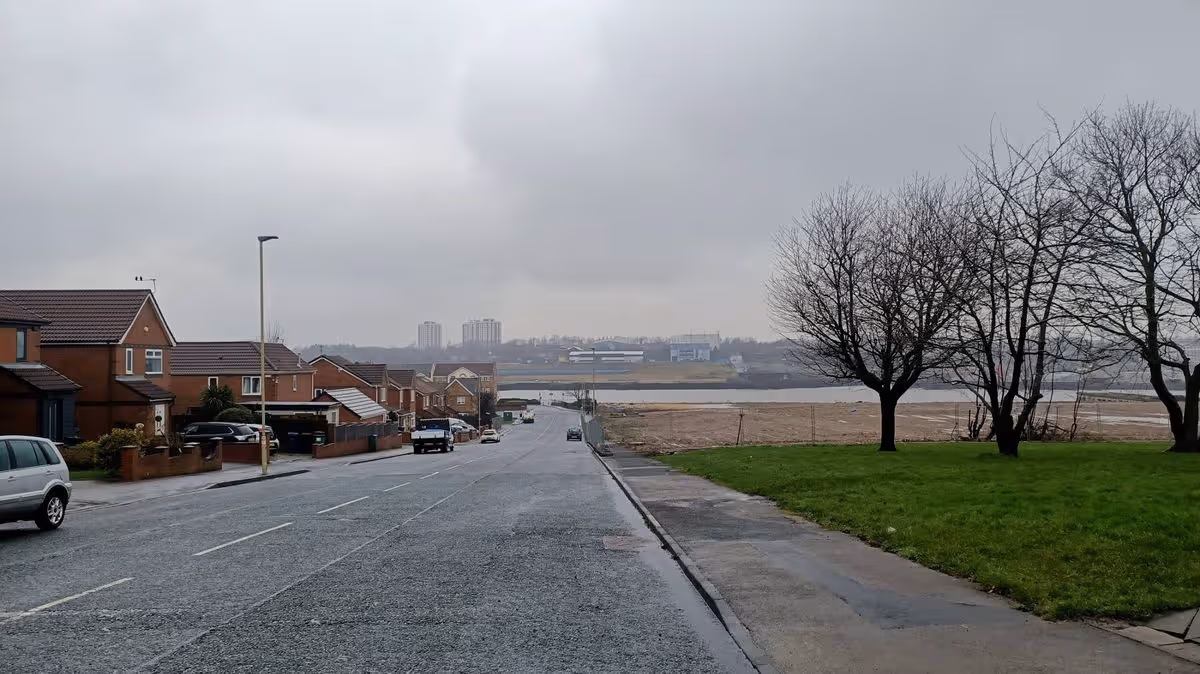 A woman, seemingly naked, being led away by police on a street in Hebburn, UK