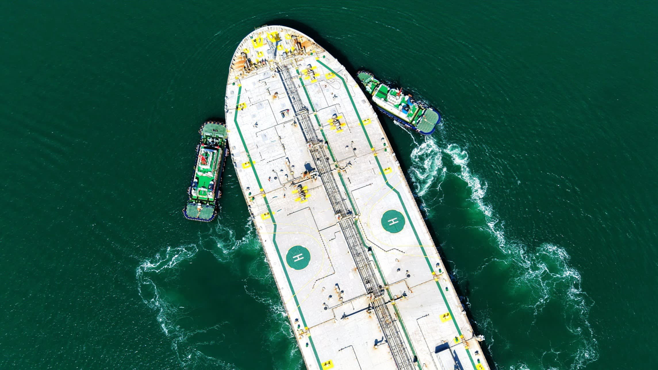 An oil pump jack operating in a field against a dramatic sky, representing the surge in crude prices