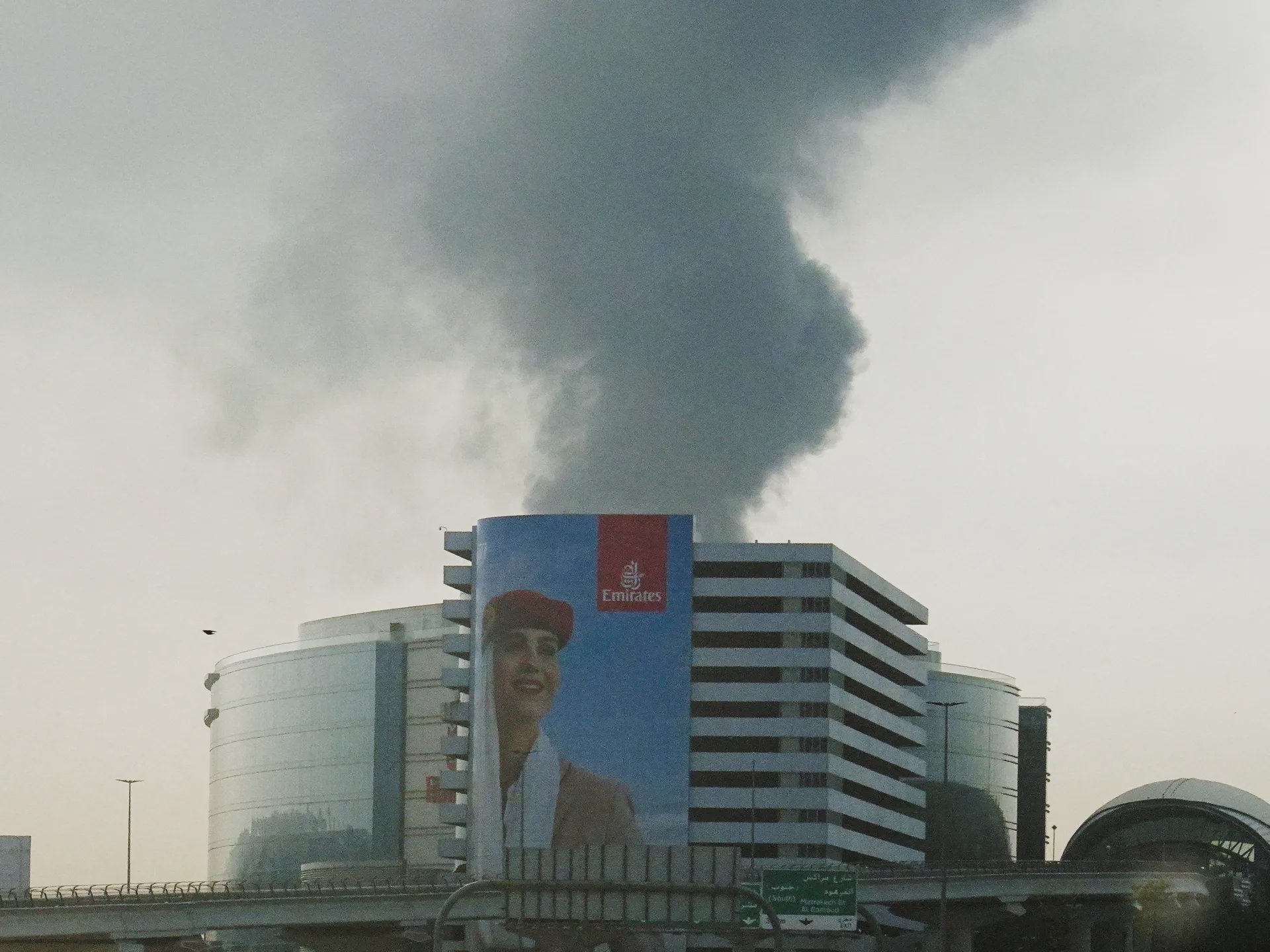 Luftaufnahme des internationalen Flughafens von Dubai mit den Stadttürmen im Hintergrund