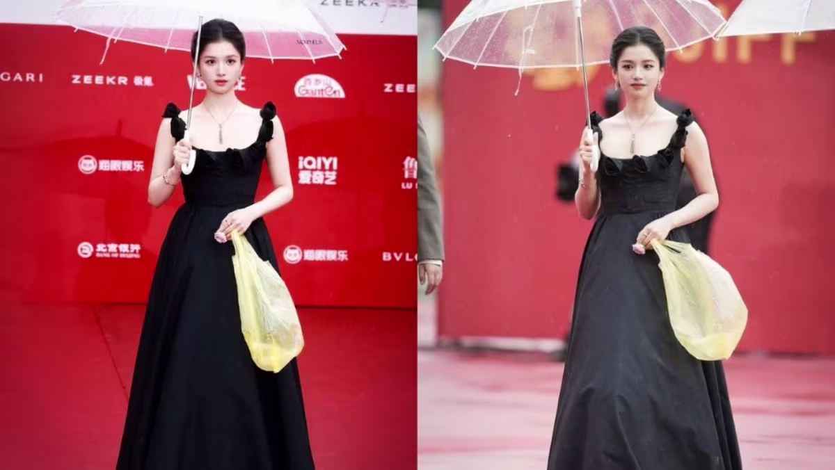 تشانغ جينغ يي تحمل كيساً بلاستيكياً أسود على السجادة الحمراء