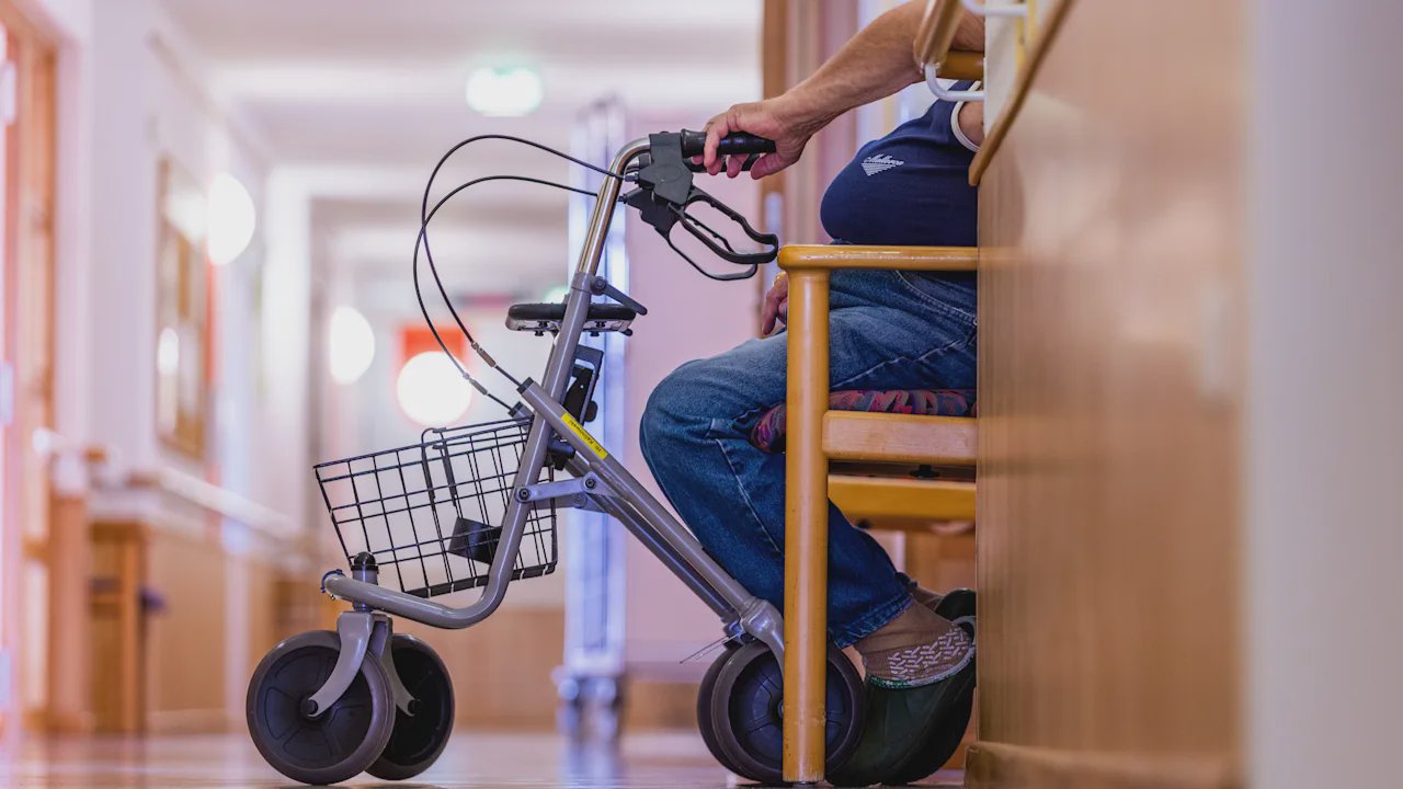 Ältere Frau im Pflegeheim blickt nachdenklich aus dem Fenster