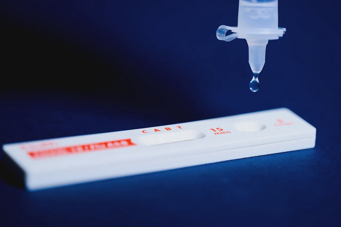 Une personne tenant un test de dépistage rapide positif à la COVID-19