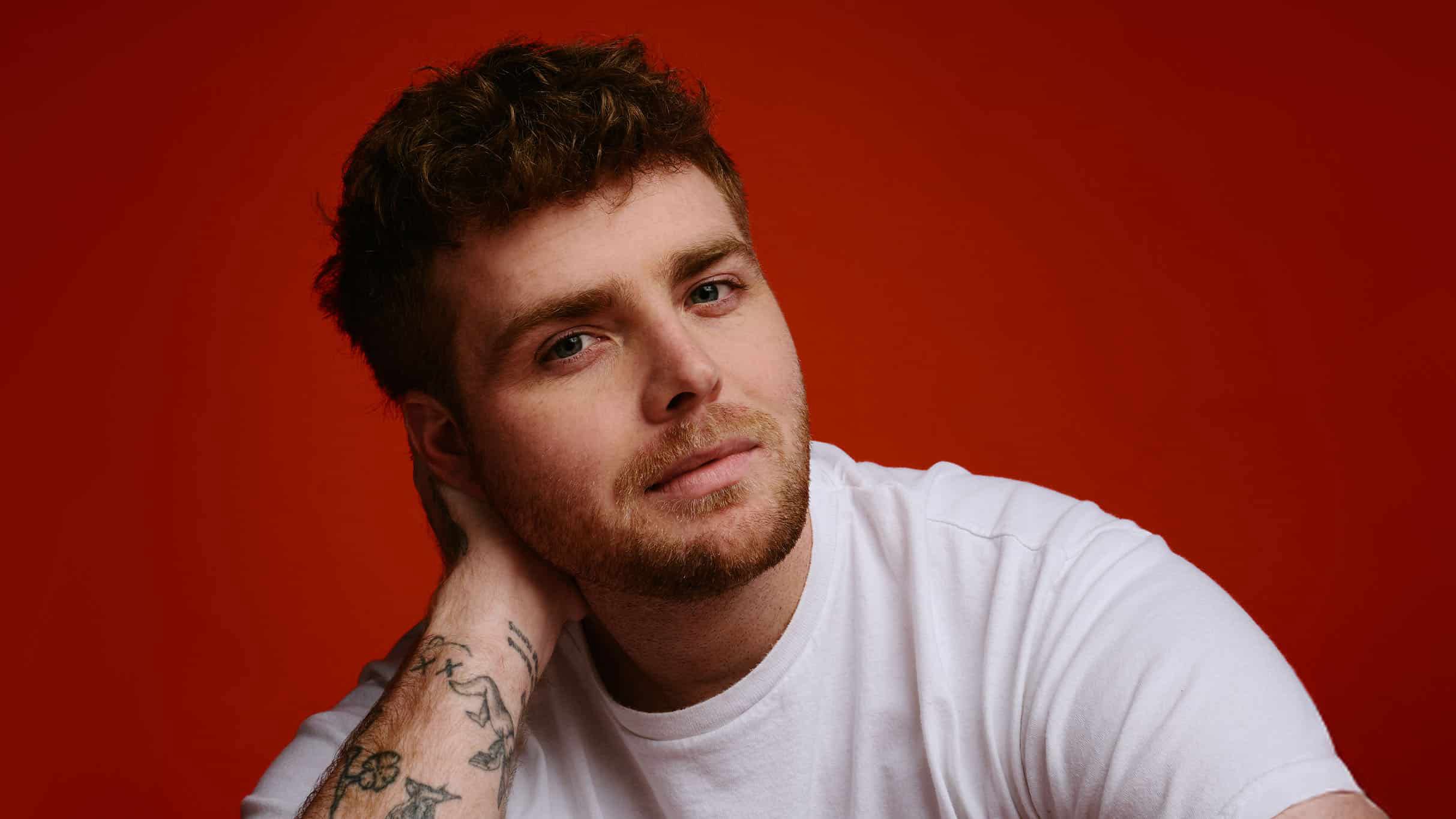 عمل فني لجولة أليكس وارين يظهر فيه المغني أمام خلفية دافئة